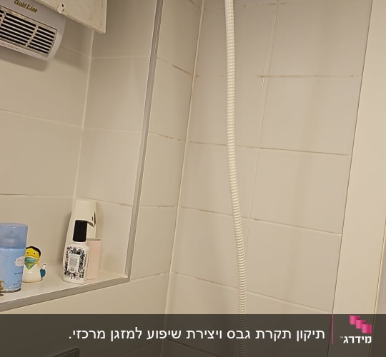 פתח שירות בתקרת גבס וצינור ניקוז בחדר רחצה
